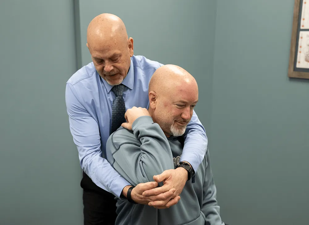 Dr. Ed performing a standing upper back adjustment