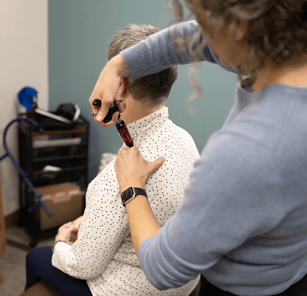 Dr. Stacy adjusting a patient's shoulder with an instrument