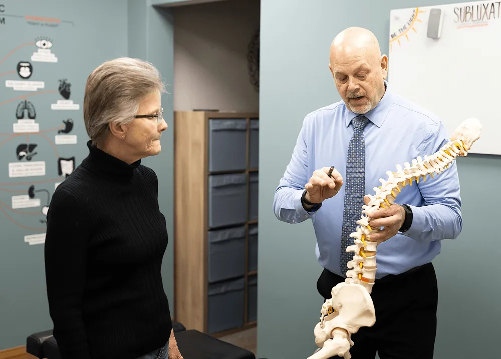 Dr. Ed explaining the spine to a patient with a spine model