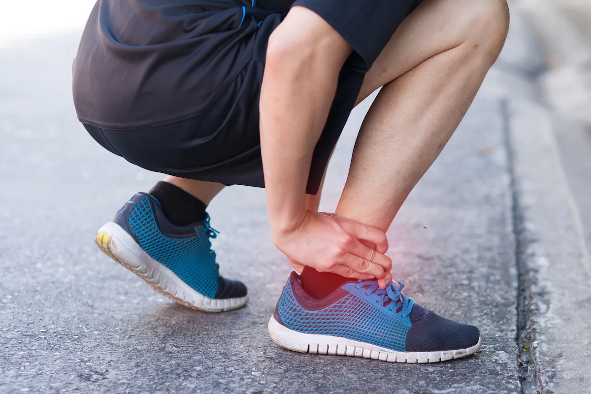 Person holding a sprained ankle