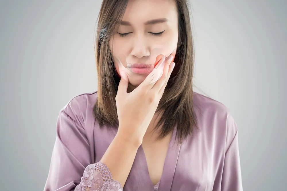 Woman holding her jaw in pain
