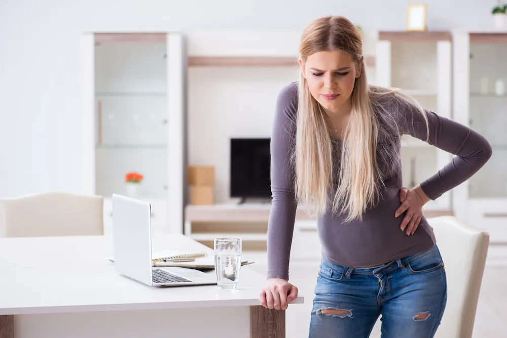 Woman holding her lower back in pain